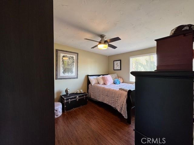 bedroom featuring ceiling fan and dark wood-type flooring