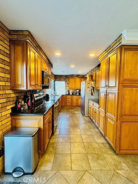 kitchen featuring stainless steel appliances and brick wall