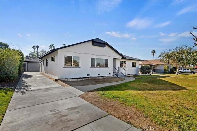 ranch-style house featuring a front lawn, a garage, and an outdoor structure