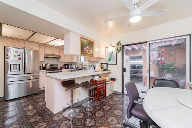 kitchen featuring ceiling fan, appliances with stainless steel finishes, sink, and a kitchen breakfast bar