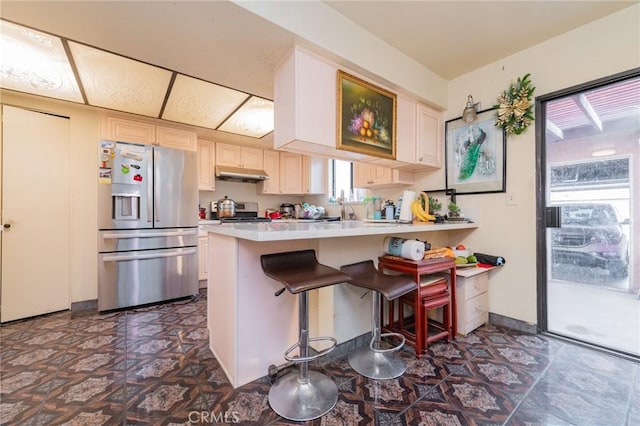 kitchen featuring a kitchen bar, sink, kitchen peninsula, and appliances with stainless steel finishes