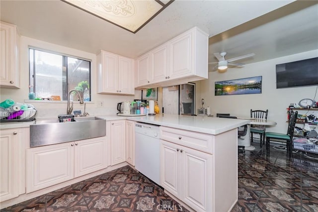 kitchen with sink, ceiling fan, white cabinetry, white dishwasher, and kitchen peninsula