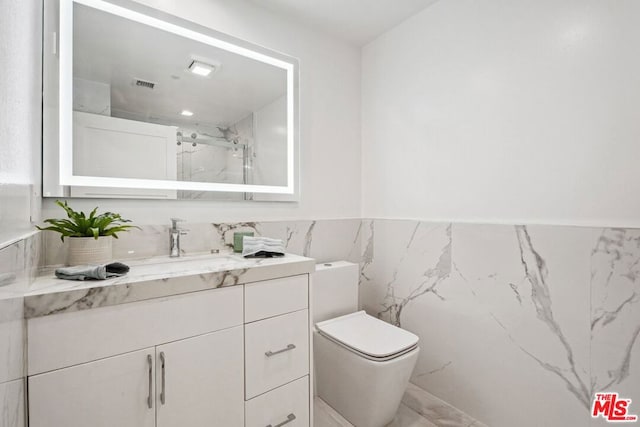 bathroom with tile walls, toilet, and vanity