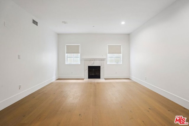 unfurnished living room featuring a fireplace and light hardwood / wood-style flooring