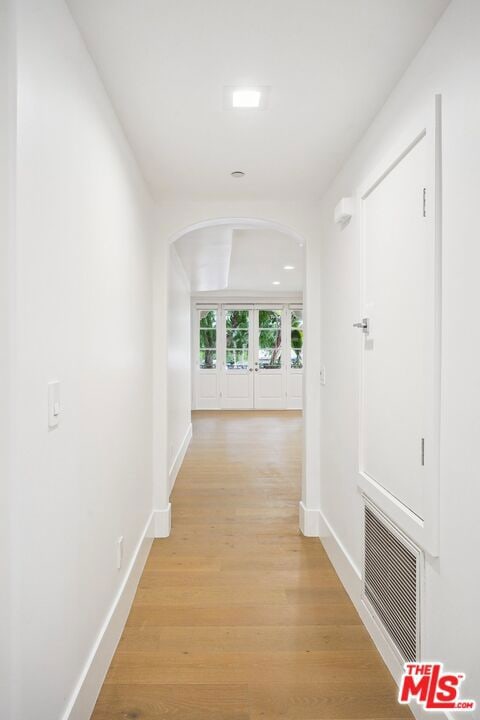 hall featuring light hardwood / wood-style flooring and french doors