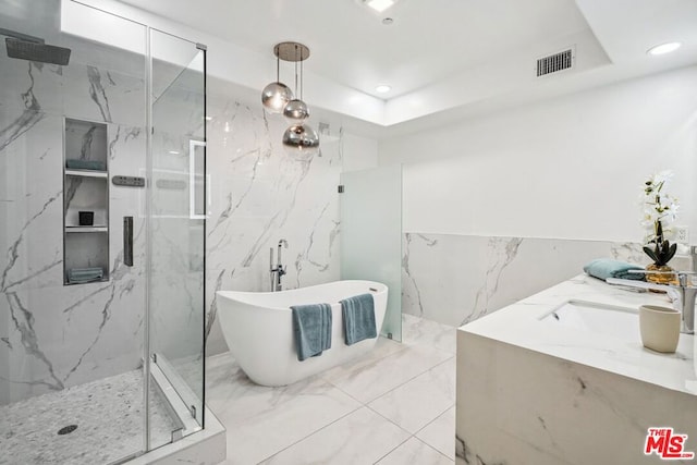 bathroom featuring vanity, a raised ceiling, and plus walk in shower