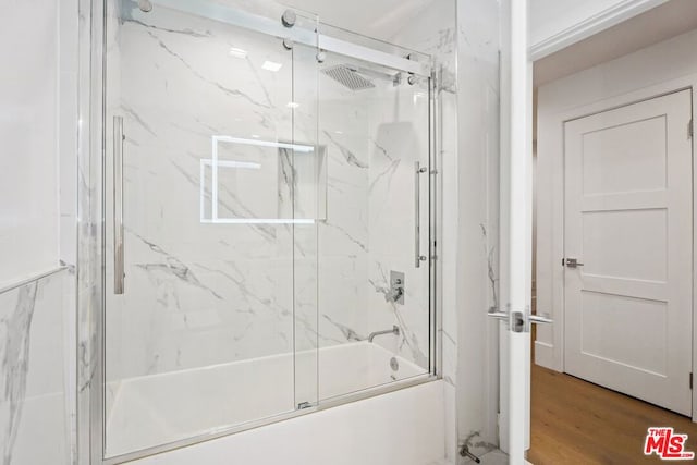 bathroom with enclosed tub / shower combo and wood-type flooring