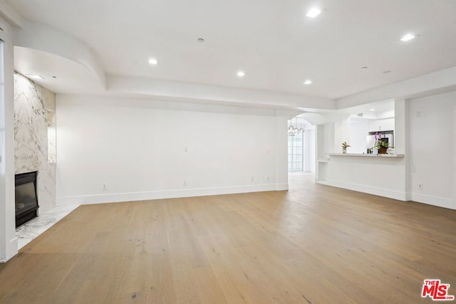 unfurnished living room with a fireplace and light hardwood / wood-style flooring