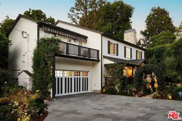 rear view of house with a balcony and a garage