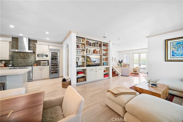 living room with light wood-type flooring and crown molding