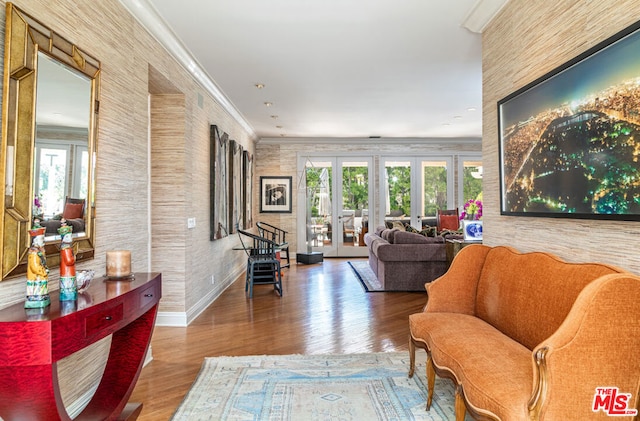 living room featuring a wealth of natural light, ornamental molding, hardwood / wood-style floors, and french doors