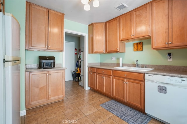 kitchen featuring light tile patterned floors, sink, and white appliances