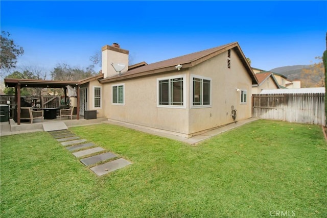 back of property with a patio area and a lawn