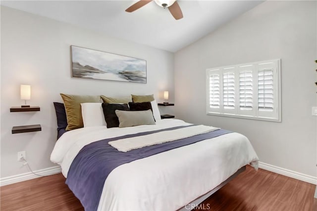 bedroom with ceiling fan, dark hardwood / wood-style floors, and lofted ceiling