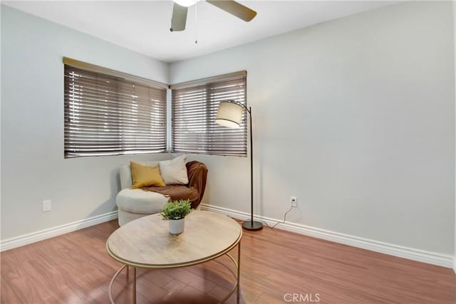 living area with ceiling fan and wood-type flooring