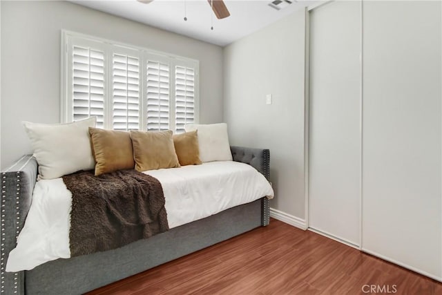 bedroom with ceiling fan, a closet, and hardwood / wood-style flooring