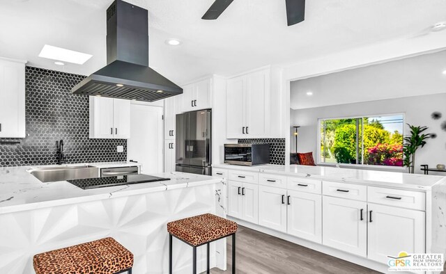 kitchen featuring white cabinets, sink, appliances with stainless steel finishes, and island exhaust hood