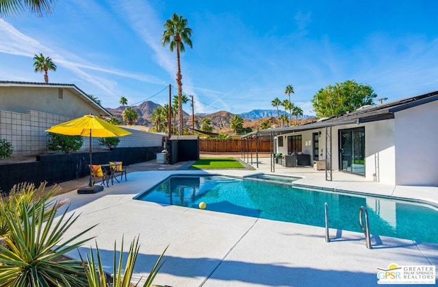 view of swimming pool with a mountain view and a patio