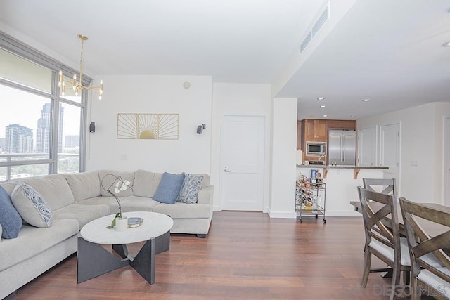 living room featuring dark wood-type flooring and an inviting chandelier