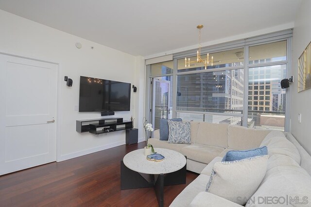 living room with a chandelier, dark wood-type flooring, and floor to ceiling windows