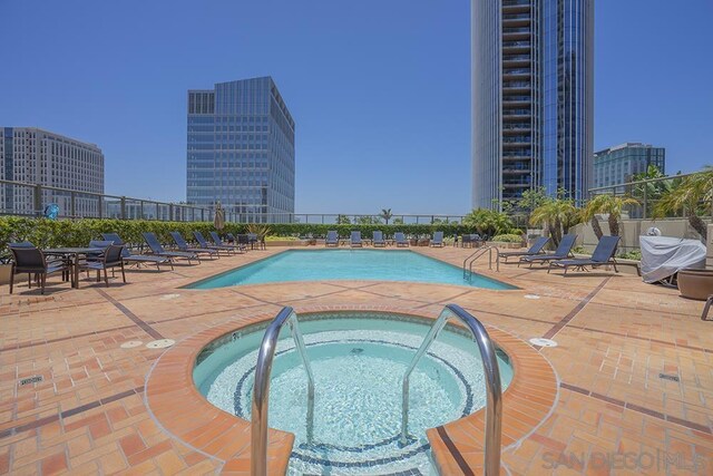 view of swimming pool featuring a patio area and a hot tub