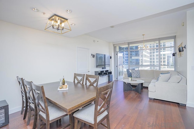 dining area with expansive windows, a notable chandelier, and dark hardwood / wood-style floors