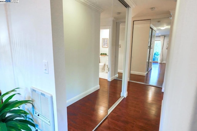 hallway featuring crown molding, dark hardwood / wood-style floors, and heating unit