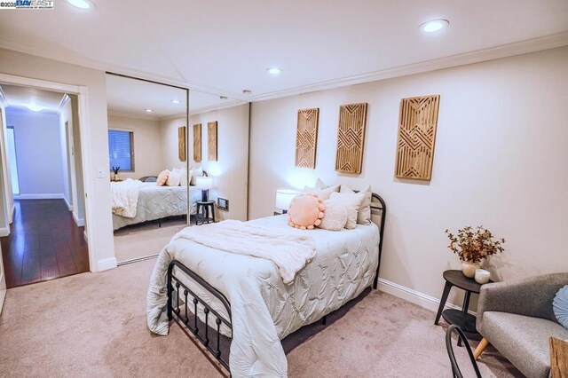 bedroom featuring a closet, carpet flooring, and crown molding