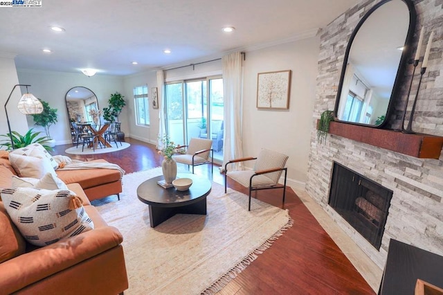 living room with ornamental molding, a fireplace, and hardwood / wood-style flooring