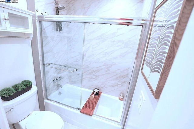 bathroom featuring combined bath / shower with glass door and toilet