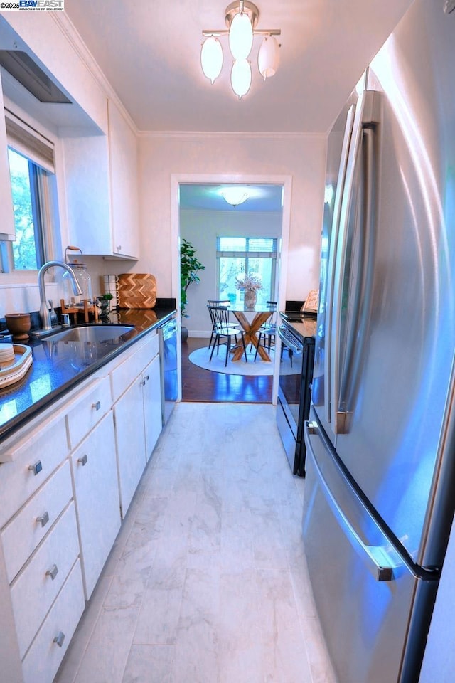 kitchen with sink, crown molding, white cabinetry, appliances with stainless steel finishes, and dark stone counters