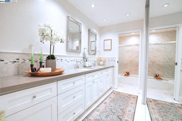 bathroom with tile walls, vanity, and separate shower and tub