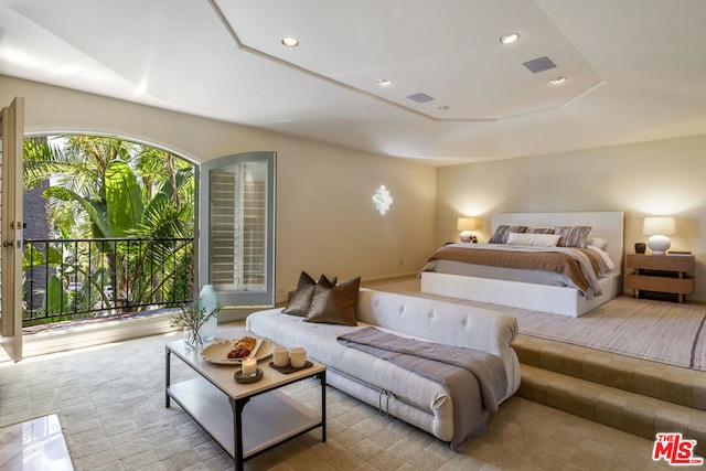 bedroom featuring a raised ceiling and access to exterior