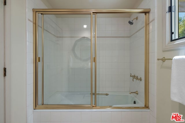 bathroom featuring bath / shower combo with glass door