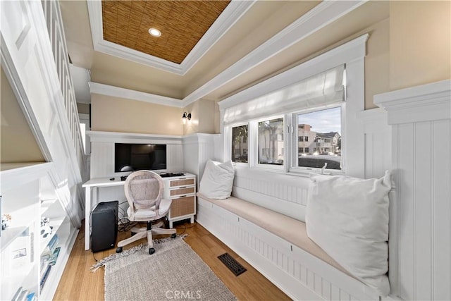 office space featuring wooden ceiling, a tray ceiling, ornamental molding, and light hardwood / wood-style floors