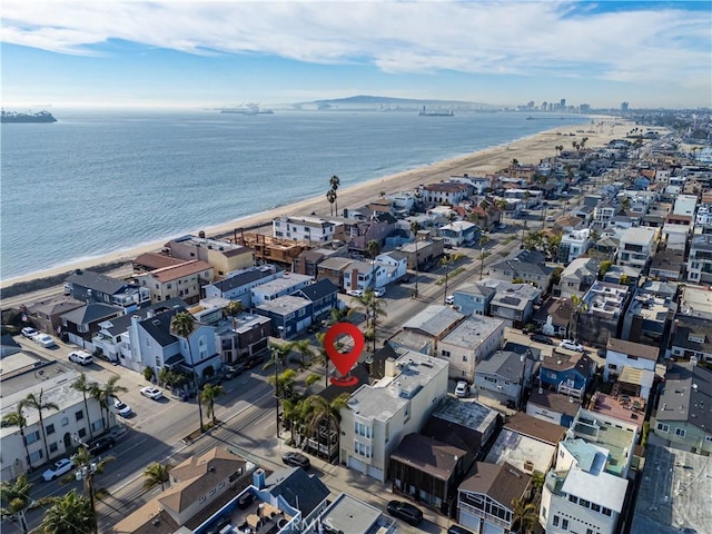 drone / aerial view with a water view and a beach view