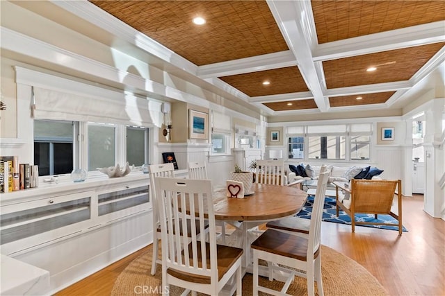 dining room with light hardwood / wood-style floors, crown molding, beam ceiling, and coffered ceiling