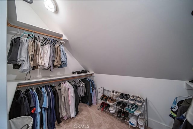 walk in closet with light carpet and lofted ceiling