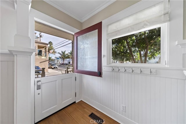 doorway featuring ornamental molding and hardwood / wood-style floors