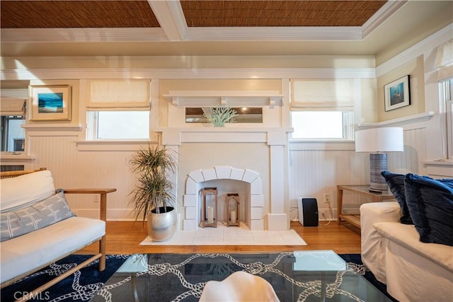 sitting room with wood-type flooring, wood walls, and crown molding