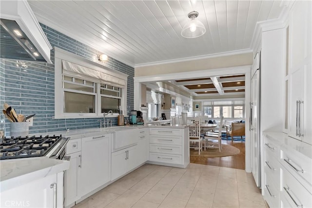 kitchen with premium range hood, white cabinetry, kitchen peninsula, and light stone counters