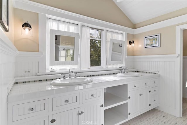 bathroom with vanity, vaulted ceiling, and tile patterned floors