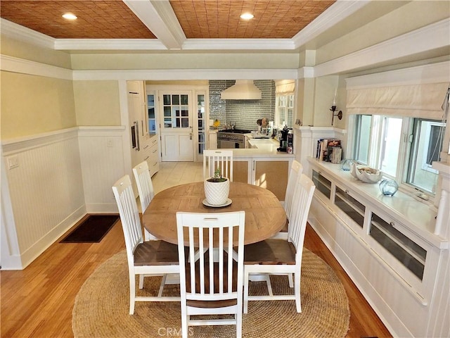 dining area with coffered ceiling, ornamental molding, light hardwood / wood-style flooring, and beamed ceiling