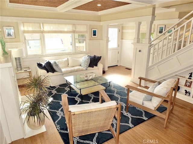 living room with beam ceiling, wood-type flooring, ornamental molding, and coffered ceiling