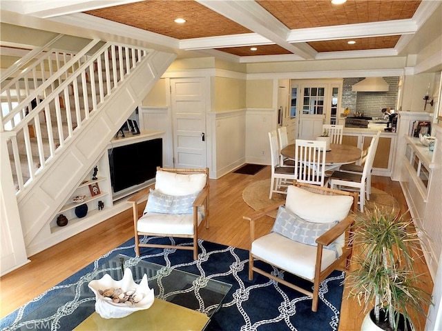 living room featuring built in shelves, ornamental molding, light hardwood / wood-style flooring, beam ceiling, and coffered ceiling