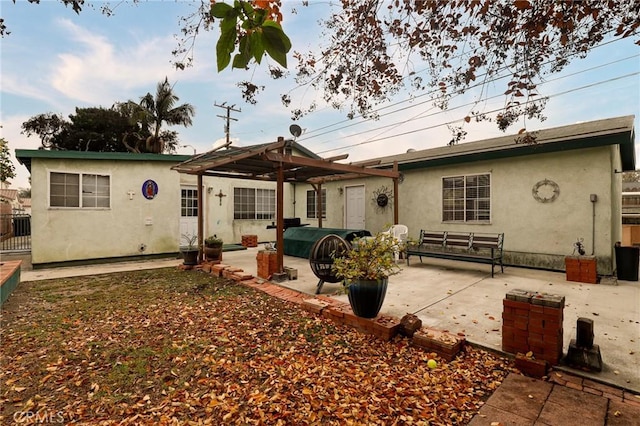 rear view of house featuring a pergola and a patio area