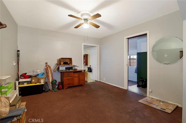 misc room featuring ceiling fan and dark carpet