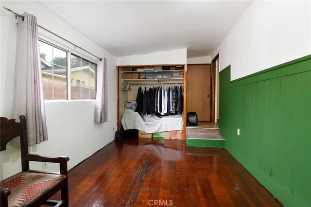 unfurnished bedroom featuring dark hardwood / wood-style floors, vaulted ceiling, and a closet