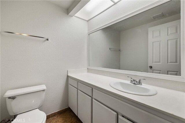 bathroom featuring toilet, tile patterned floors, and vanity