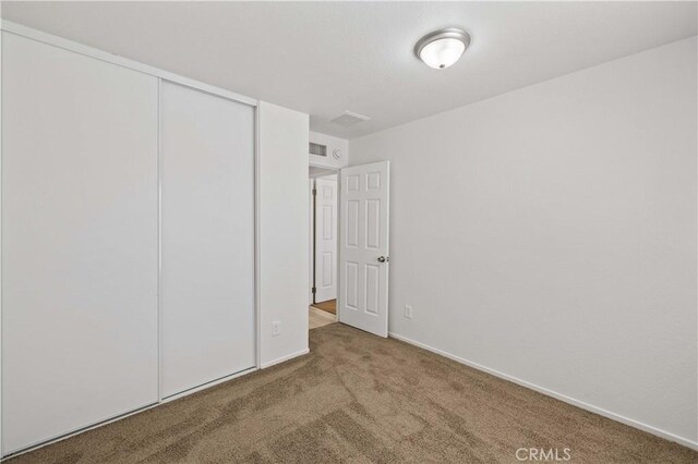 unfurnished bedroom with a closet and carpet